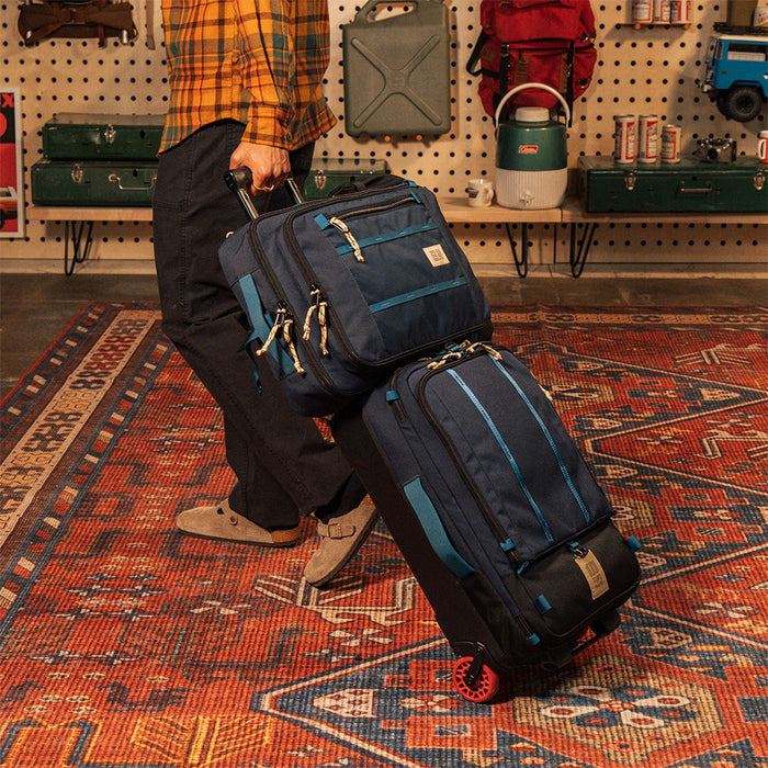General model shot of Global Travel Bag Roller Bag in "Navy" with Global Travel Bag 30L on handle being pulled