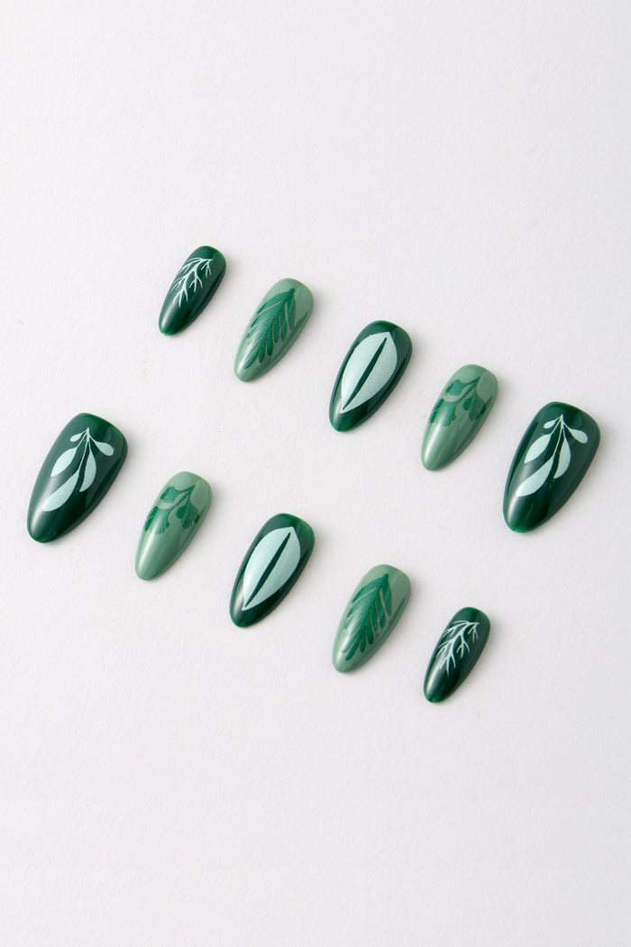 Green press-on nails with white leaf designs, inspired by Happy Herbs by Lauren Hom.