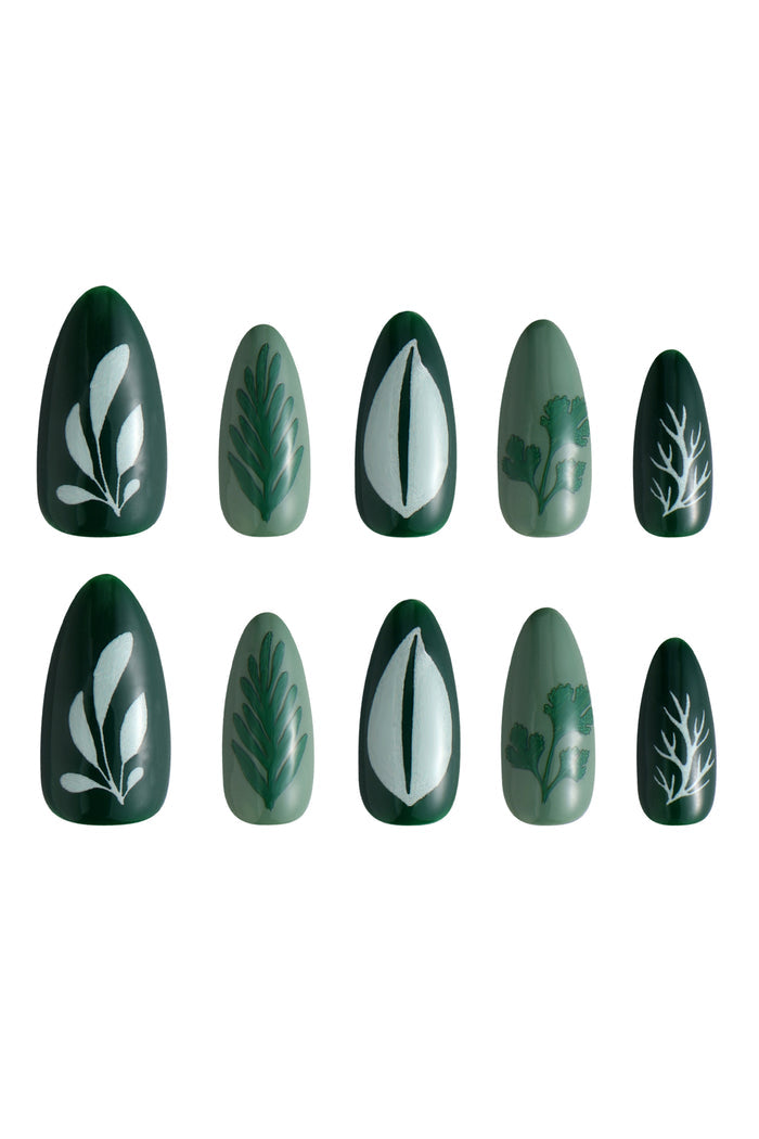 Green press-on nails with nature-inspired designs: leaves and branches.