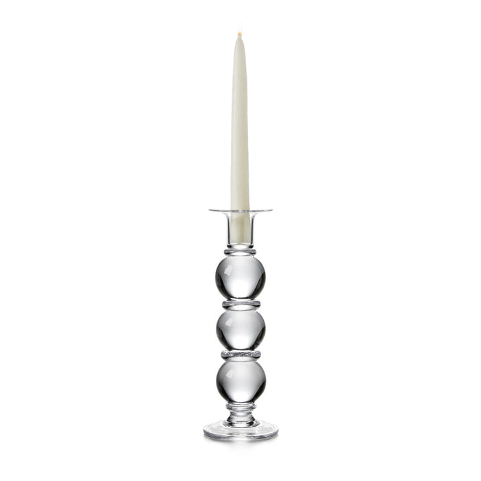 Clear glass candlestick with three stacked spheres, metal candle holder ring, and cream taper candle.