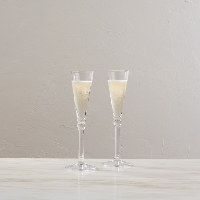 Two clear champagne flutes filled with sparkling champagne, displayed side by side.