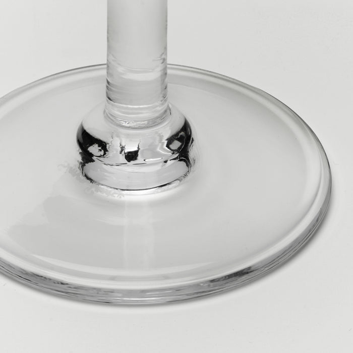 Close-up of a clear glass wine glass base and stem on a light gray background.