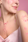 Y2K temporary tattoos featuring pink hearts and bows on a woman's skin.