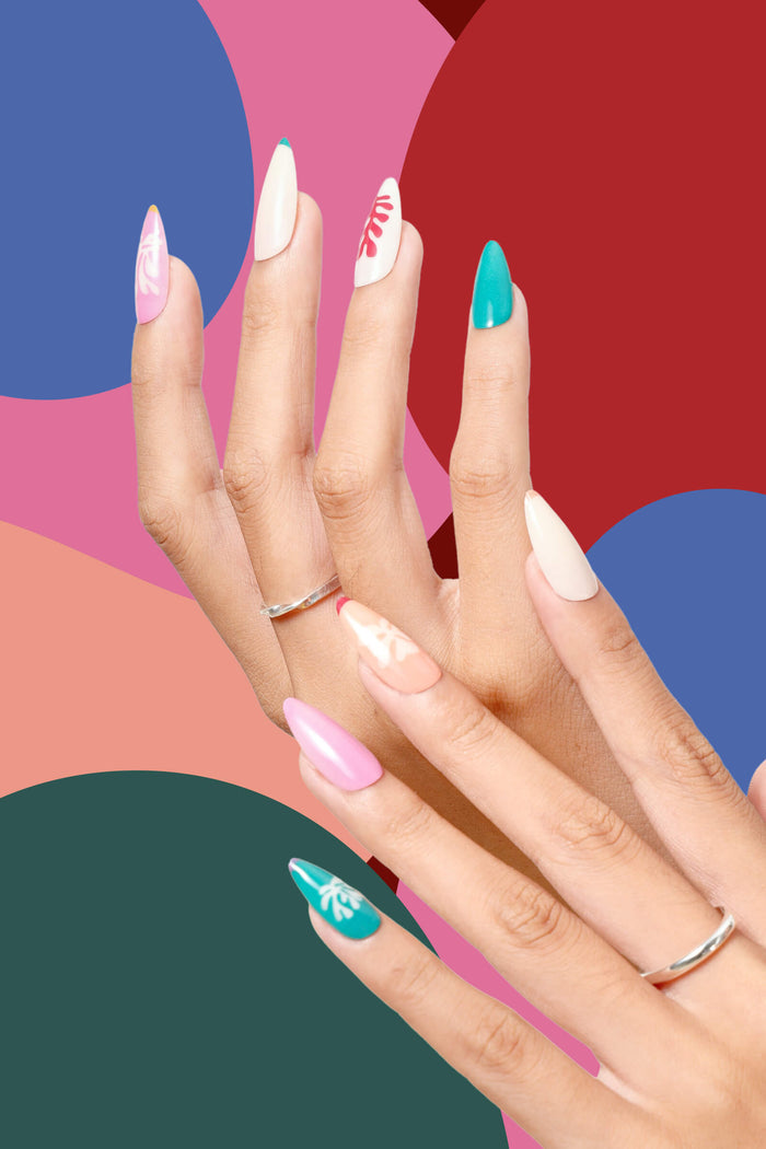 Almond press-on nails in floral and abstract designs, in shades of pink, white, beige, and teal, on hands against a colorful background.