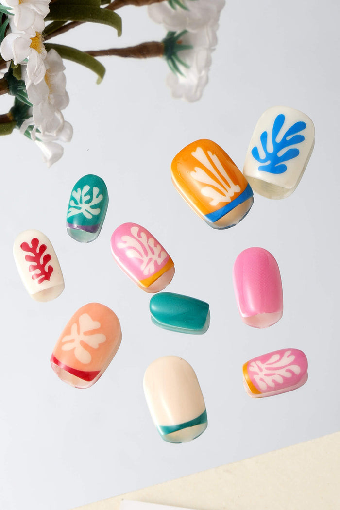 Assortment of square press-on nails featuring Matisse-inspired cut-out designs in vibrant colors.
