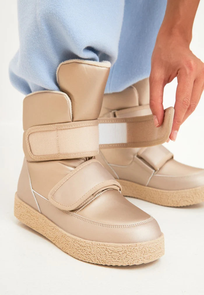 Stay warm and stylish this winter with these beige high-top winter boots featuring Velcro straps. Perfect for all your winter adventures, these high-top boots will keep your feet cozy and fashionable all season long.