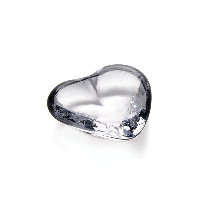 Clear glass heart-shaped object with smooth curved surface and reflective finish.