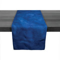 Deep indigo linen table runner with textured surface displayed on dark wood table.