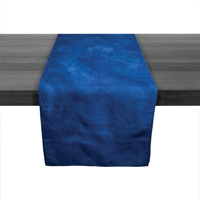Deep indigo linen table runner with textured surface displayed on dark wood table.