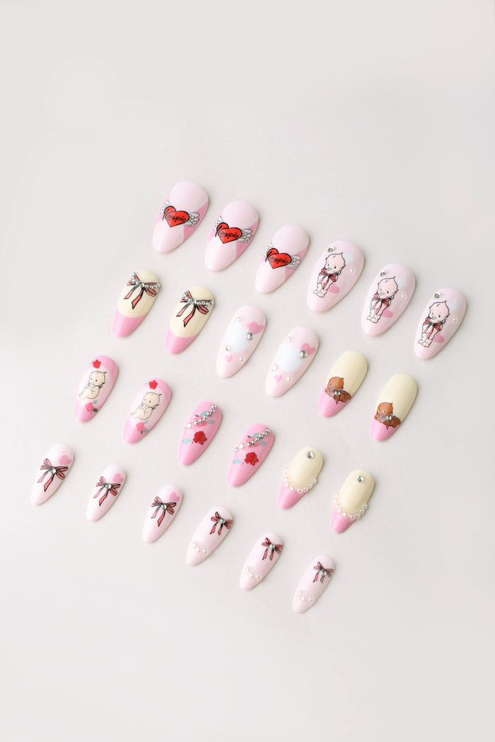 Assorted Kewpie pastel press-on nails with Valentine's designs including hearts, bows, and characters.