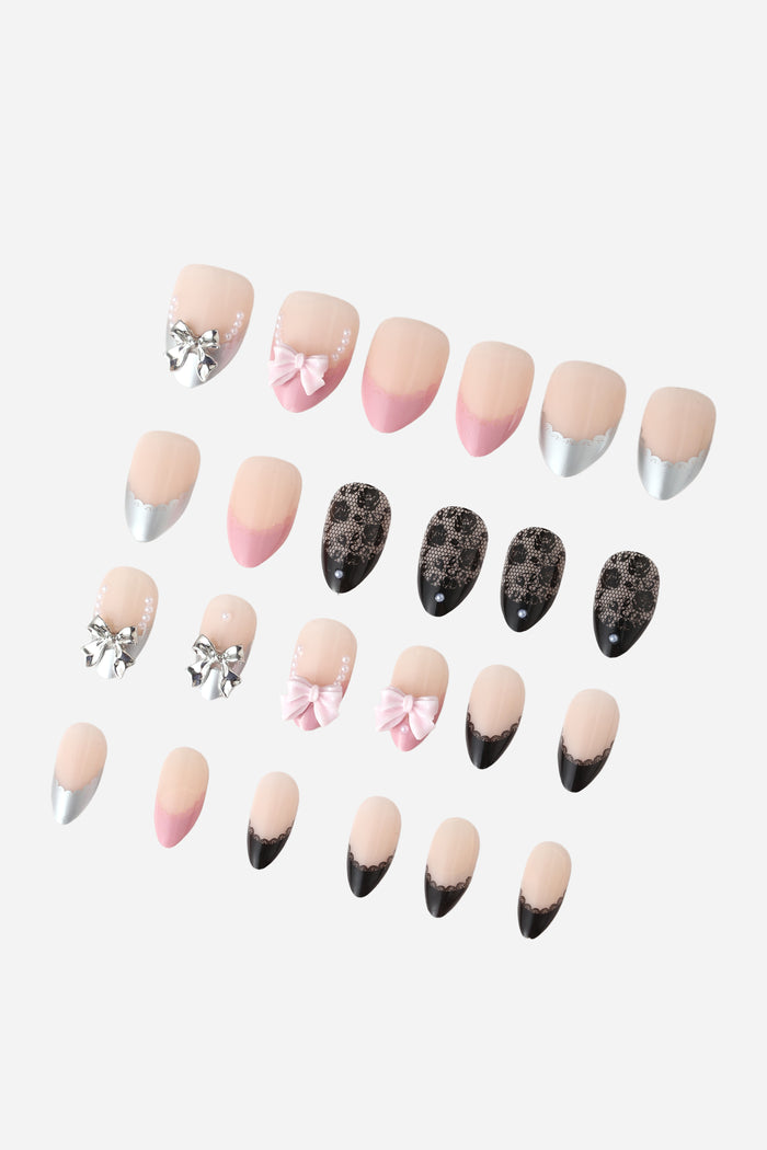 Short almond press-on nails with lace, bow, and pearl designs in pink, silver, and black.