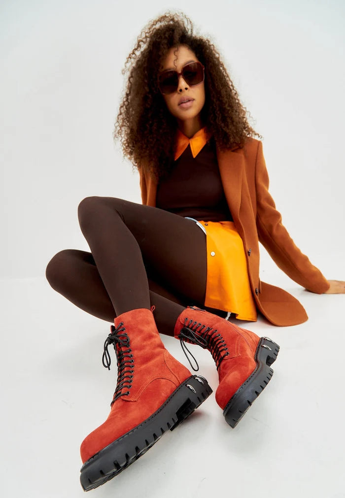 A trendy pair of red lace-up combat boots with a chunky sole, perfect for adding a fashionable edge to any outfit - a must-have for women's fashion combat boots collection.