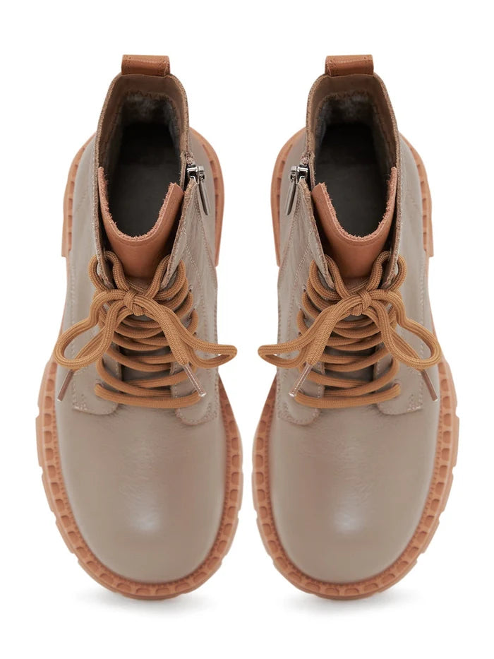 A stylish pair of beige leather lace-up ankle boots for women, perfect for fashion-forward looks.