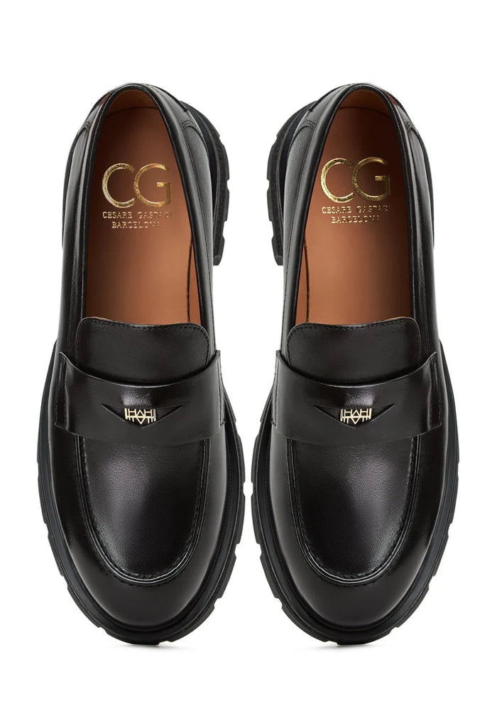 A pair of stylish Mariana black leather loafers with platform soles, making them a fashionable choice in women's footwear.