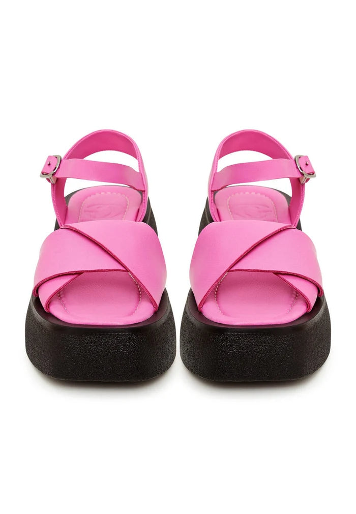 A stylish pair of fuchsia leather platform sandals for women, featuring high heels and a designer look.