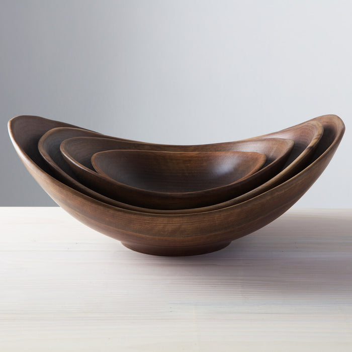 Three nesting walnut bowls with irregular live edges, arranged largest to smallest.