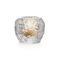 Silver textured tealight holder with lit candle visible inside.