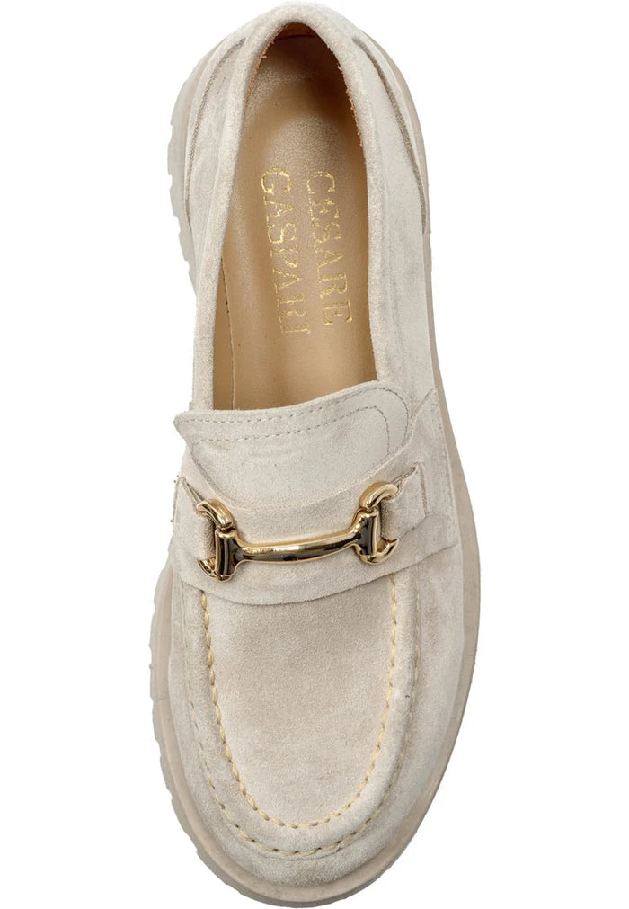 A stylish pair of Luxe Glide Gold-Bit Loafers, also known as Josephine Beige shoes, perfect for the modern woman who loves designer loafers. These luxury gold-bit footwear are made of beige leather and designed as slip-on shoes.