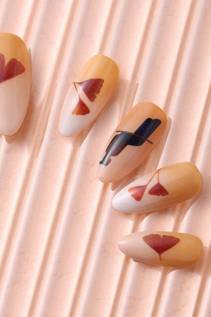 Autumn Ginkgo press-on nails with red ginkgo leaf design on ribbed pink surface.
