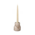 Beige concrete candle holder with taper candle inserted in top opening and tealight cup on lower section.