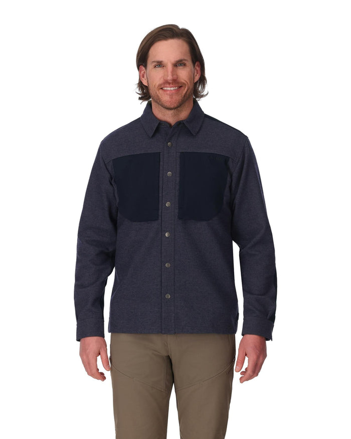 Man wearing a dark blue flannel shirt with black patchwork on a white background