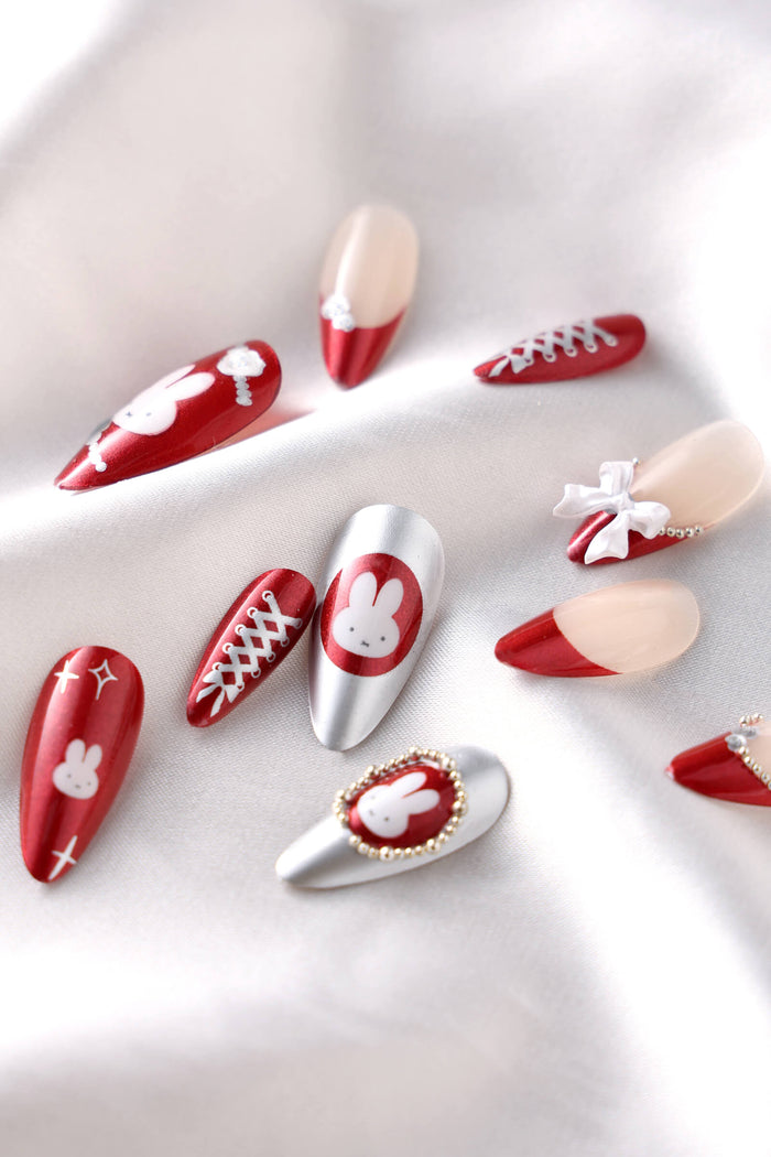Burgundy almond press-on nails with Miffy character designs and red French tips.