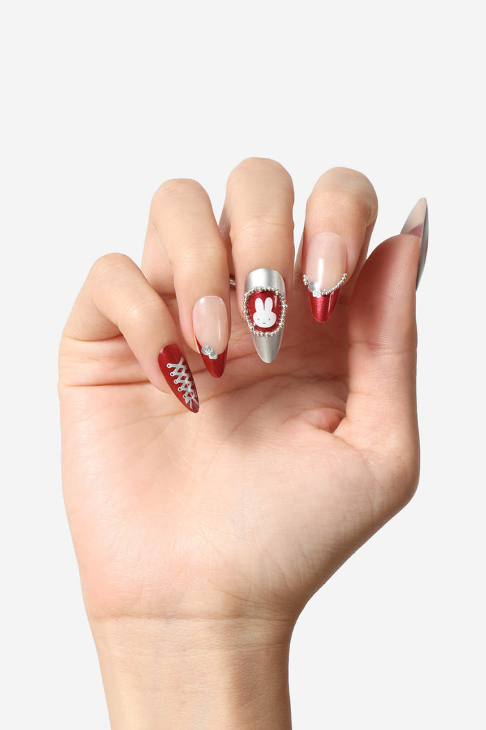 Almond press-on nails with Miffy graphic, red lace-up design, and pearl accents.