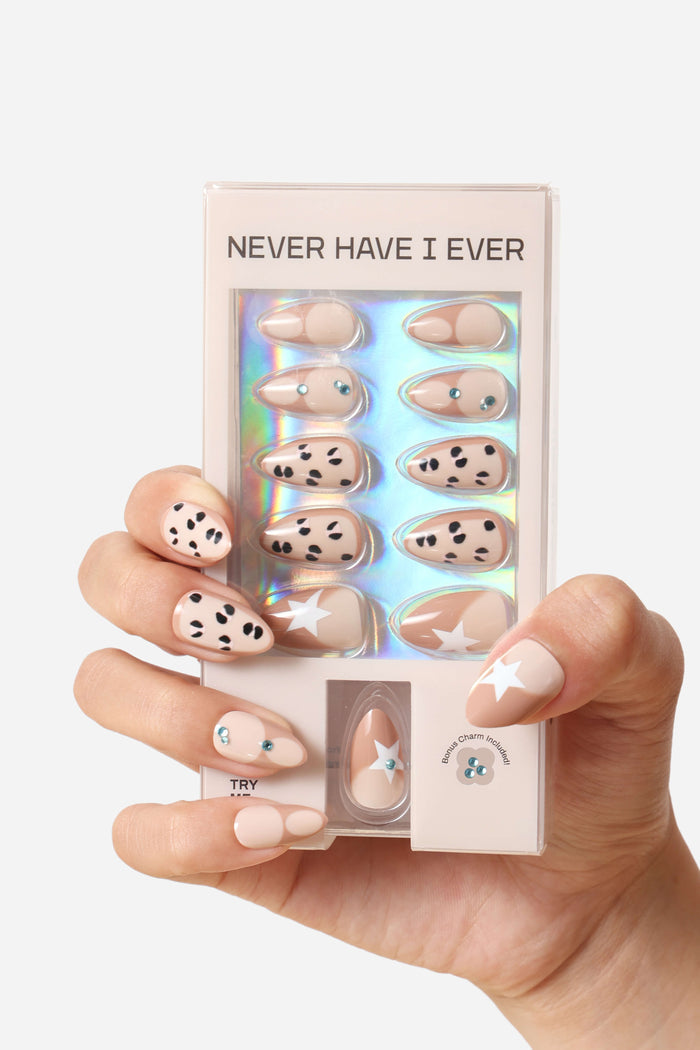 Mocha Me Wild short almond press-on nails with dalmatian spots and star designs.
