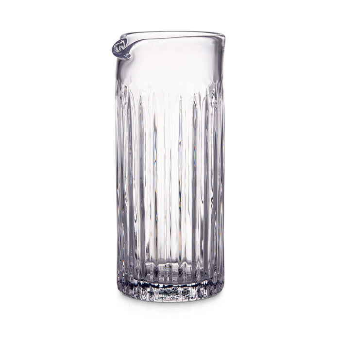 Clear glass pitcher with vertical ribbed pattern and curved handle spout.