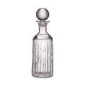 Clear glass decanter with vertical ribbed pattern and spherical glass stopper.
