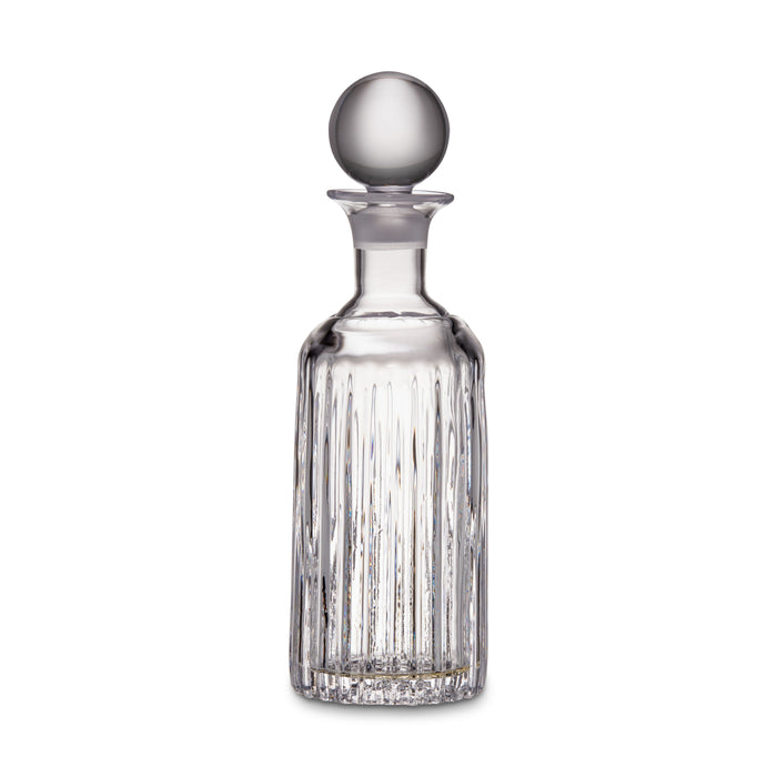 Clear glass decanter with vertical ribbed pattern and spherical stopper on white background.