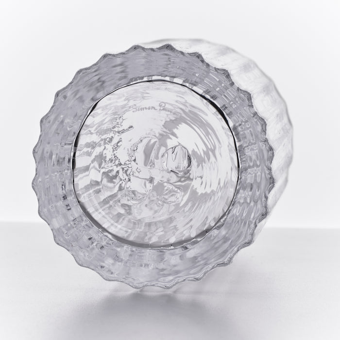 Clear glass decanter with textured wavy edges and engraved design on the bottom, shown from above.