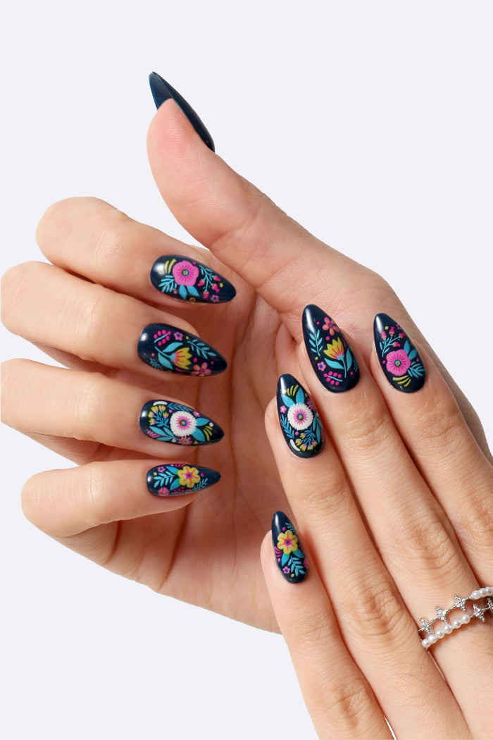 Moody Blooms by Jess Phoenix press-on nails with dark navy base and colorful floral designs.