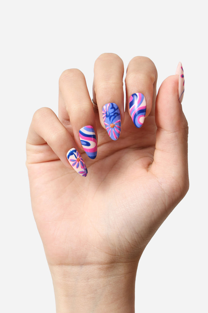 Mystic Daisy press-on nails feature a retro-inspired design with swirling pink, blue, and white patterns and floral accents.