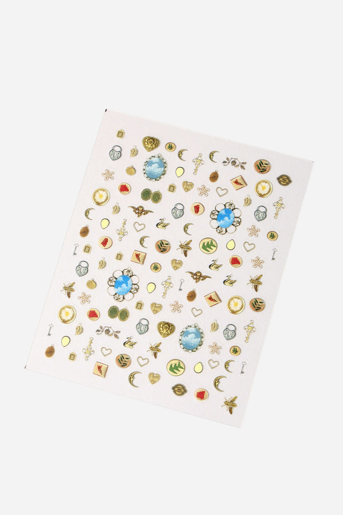 Nail Sticker by Sirrah Archive sheet with gold charms, moons, hearts, and decorative elements.