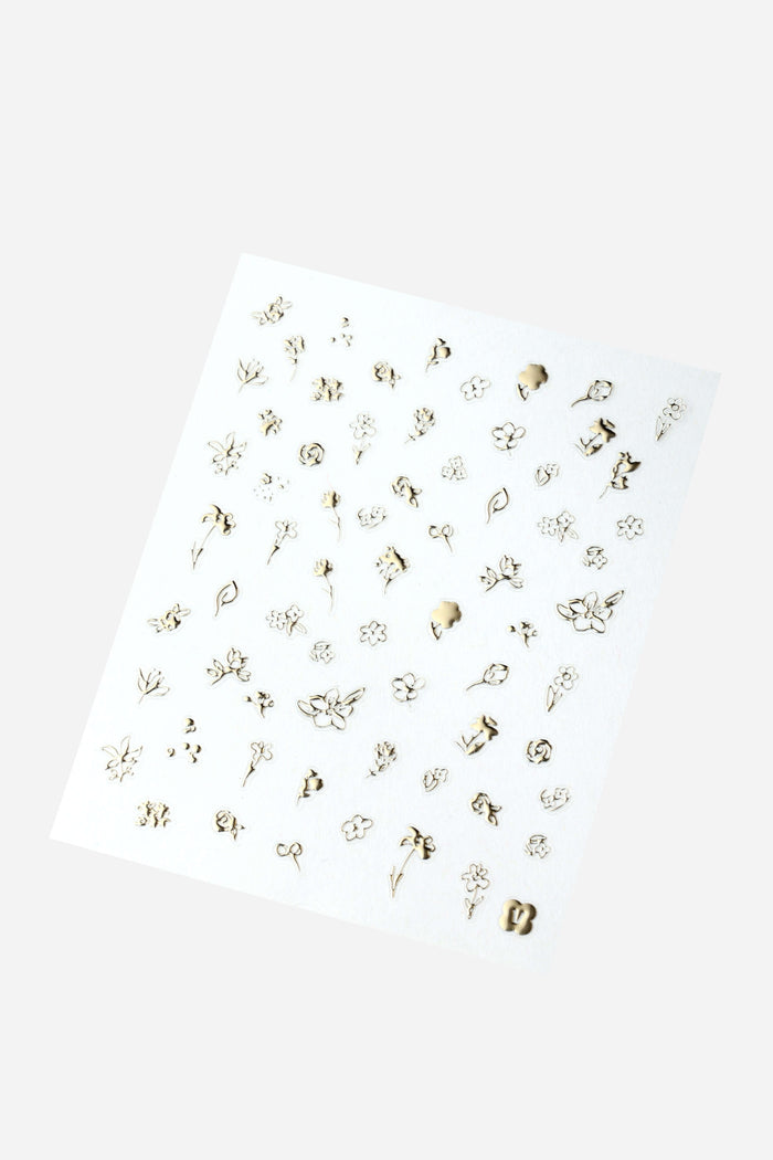 Sheet of gold foil nail stickers featuring delicate floral designs, including roses, lilies, and abstract flowers.