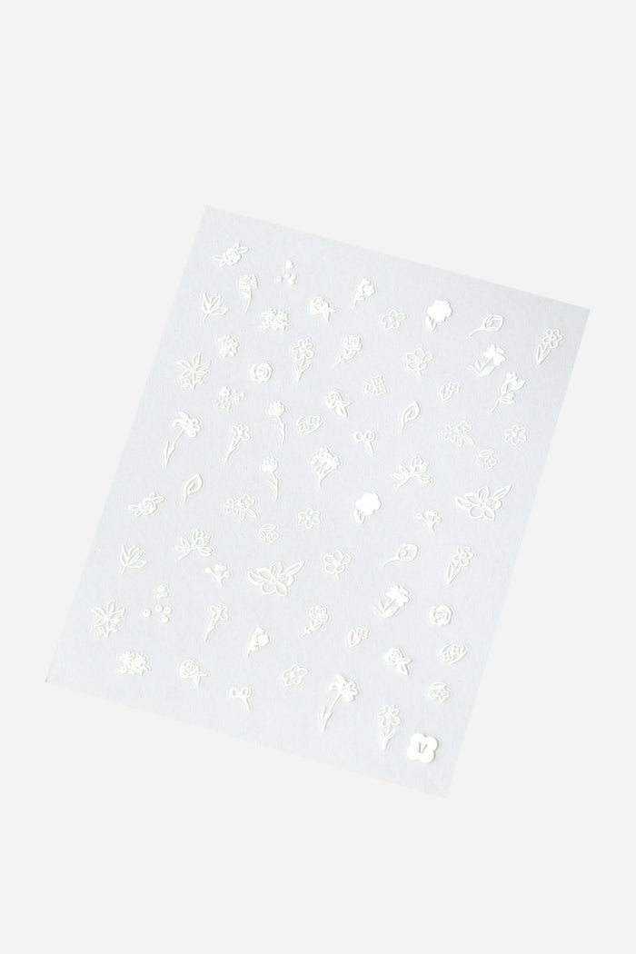 Sheet of white nail stickers featuring various delicate floral designs and leaves.