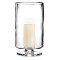Clear glass hurricane with pedestal base holding a cream-colored pillar candle.