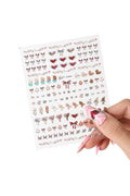 Sheet of Onch x Kewpie nail stickers featuring illustrations of babies, bows, hearts with wings, and floral borders.
