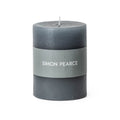 Pewter-colored pillar candle with gray band label and white center wick.