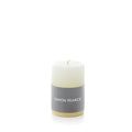 Ivory pillar candle with gray band label and cream-colored base.