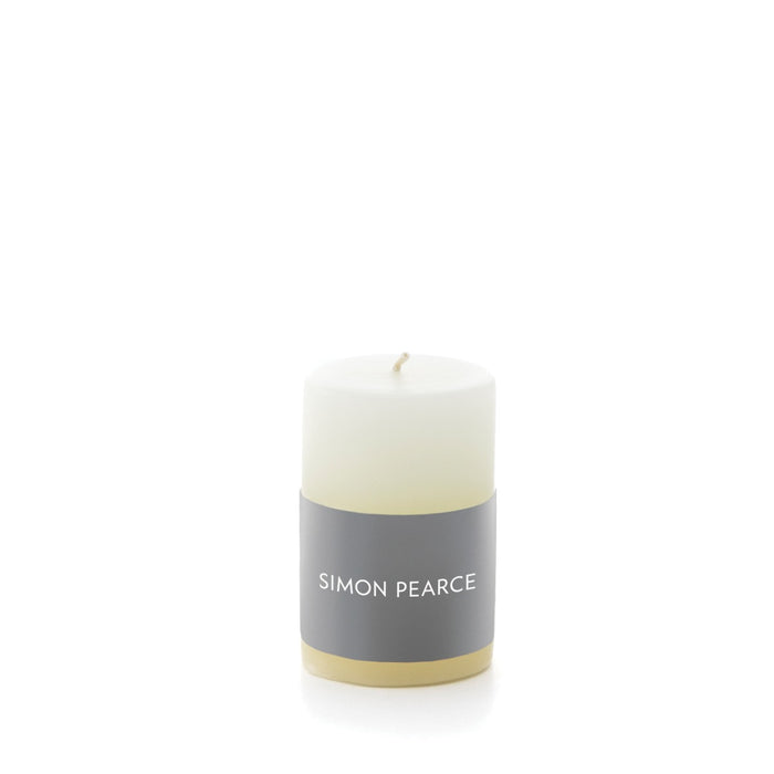Ivory pillar candle with gray band label and cream-colored base.