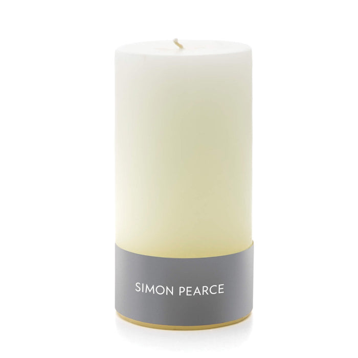 Ivory pillar candle with gray band label and tan wick, gold base trim.