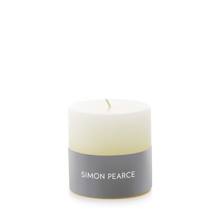 Ivory pillar candle with gray band label and single wick.