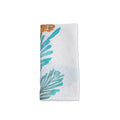 White linen napkin with teal and brown pine branch and evergreen print design.