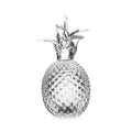 Fresh pineapple with textured skin and leafy crown on white background.