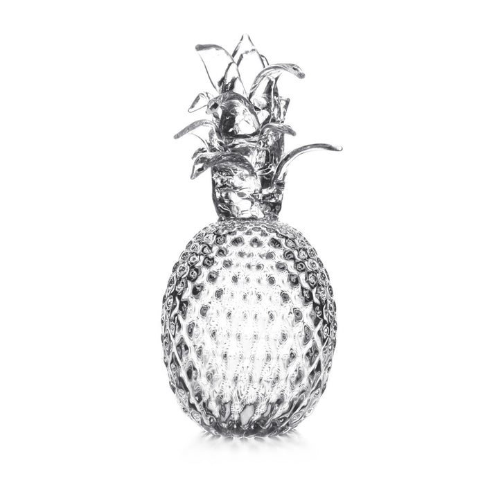 Fresh pineapple with textured skin and green crown leaves against white background.