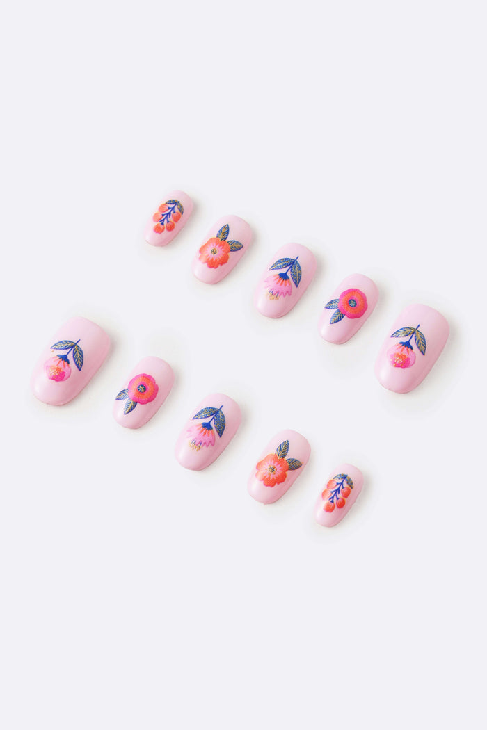 Pink press-on nails with floral designs, featuring orange and blue accents.