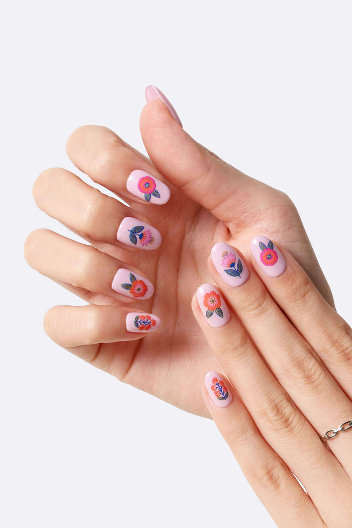 Pink press-on nails with abstract floral designs by Jess Phoenix.