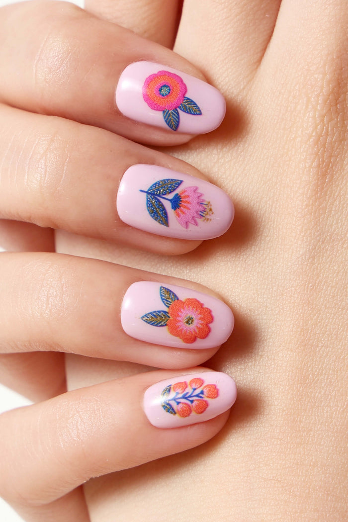 Pink press-on nails with floral designs by Jess Phoenix.